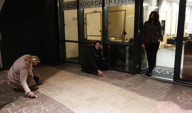 <p>Winny Hofland en Arnoud Proos tekenen op de stoep van de kapsalon.</p>