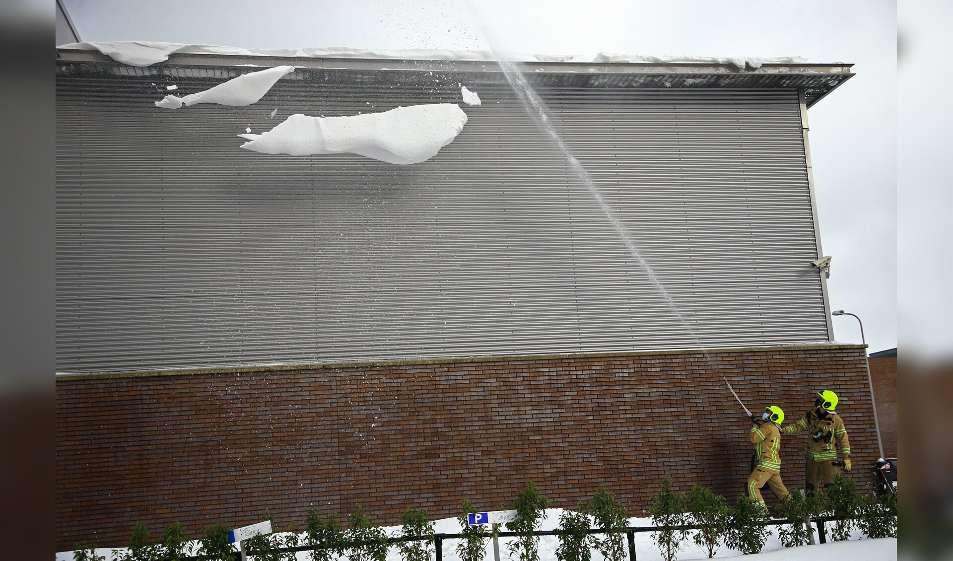 Er werd een flinke hoeveelheid sneeuw en ijs van de dakrand verwijderd. 