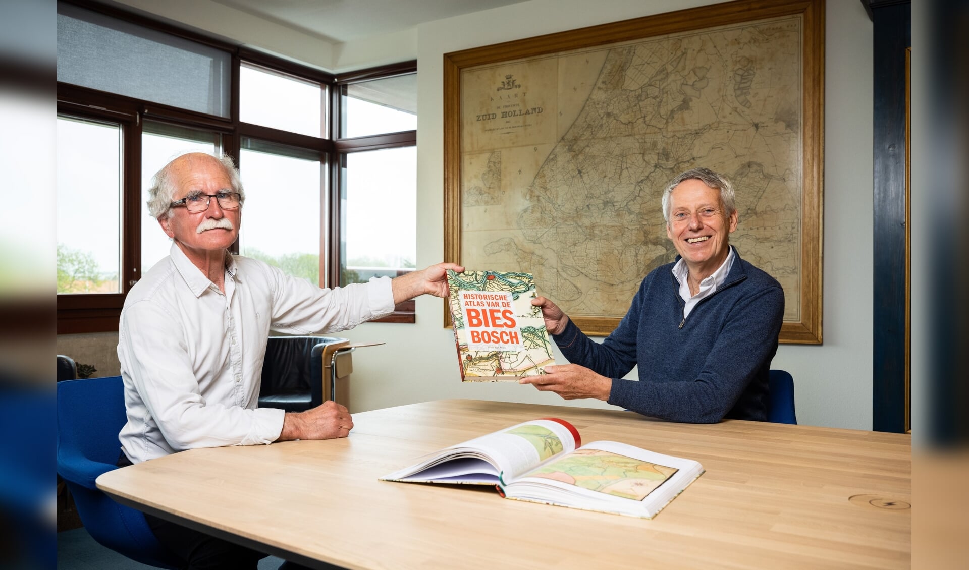Auteur Wim van Wijk overhandigt het eerste exemplaar van de Biesboschatlas aan dijkgraaf Jan Bonjer.