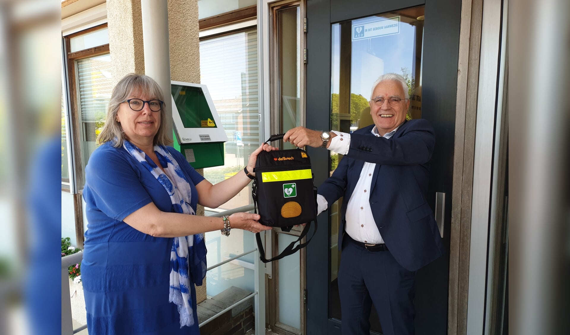 Wethouder Cees Schaap en oud-gemeenteraadslid Marianne Thijsse-Humme met de nieuwe AED.