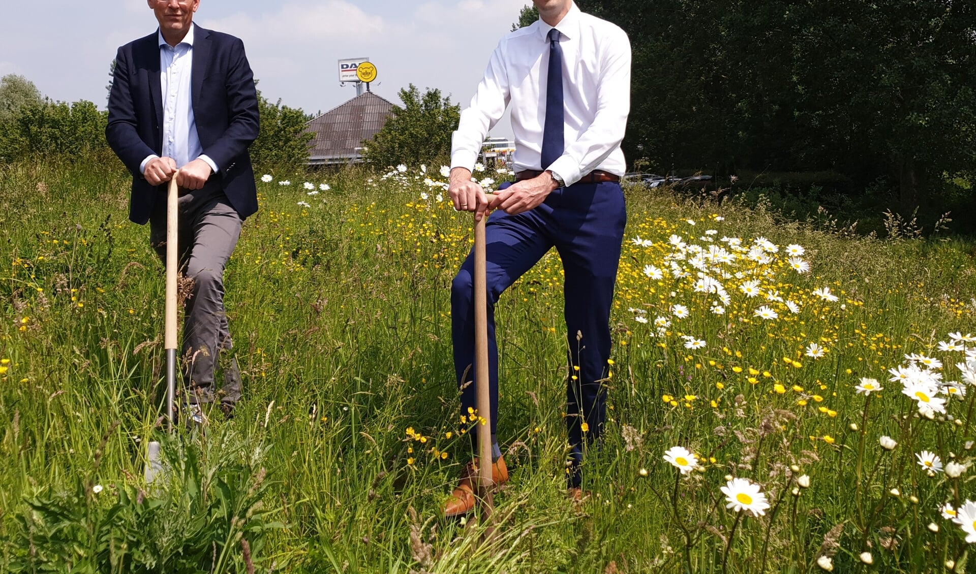 Ondernemer Jeroen Gouw en wethouder Arnoud Proos starten met het afgraven van de vervuilde hoop grond. 