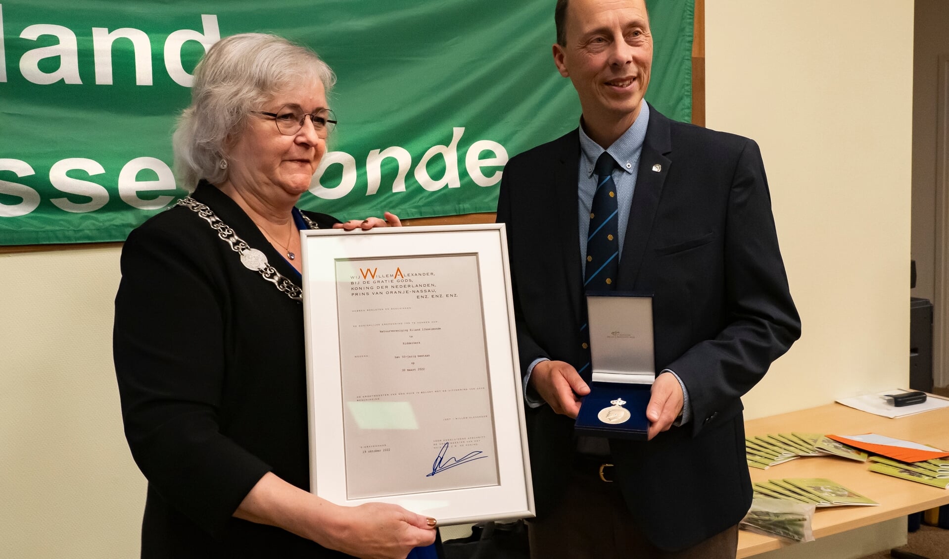 Voorzitter Hans Olthoff neemt de koninklijke erepenning voor de Natuurvereniging Eiland IJssselmonde in ontvangst.