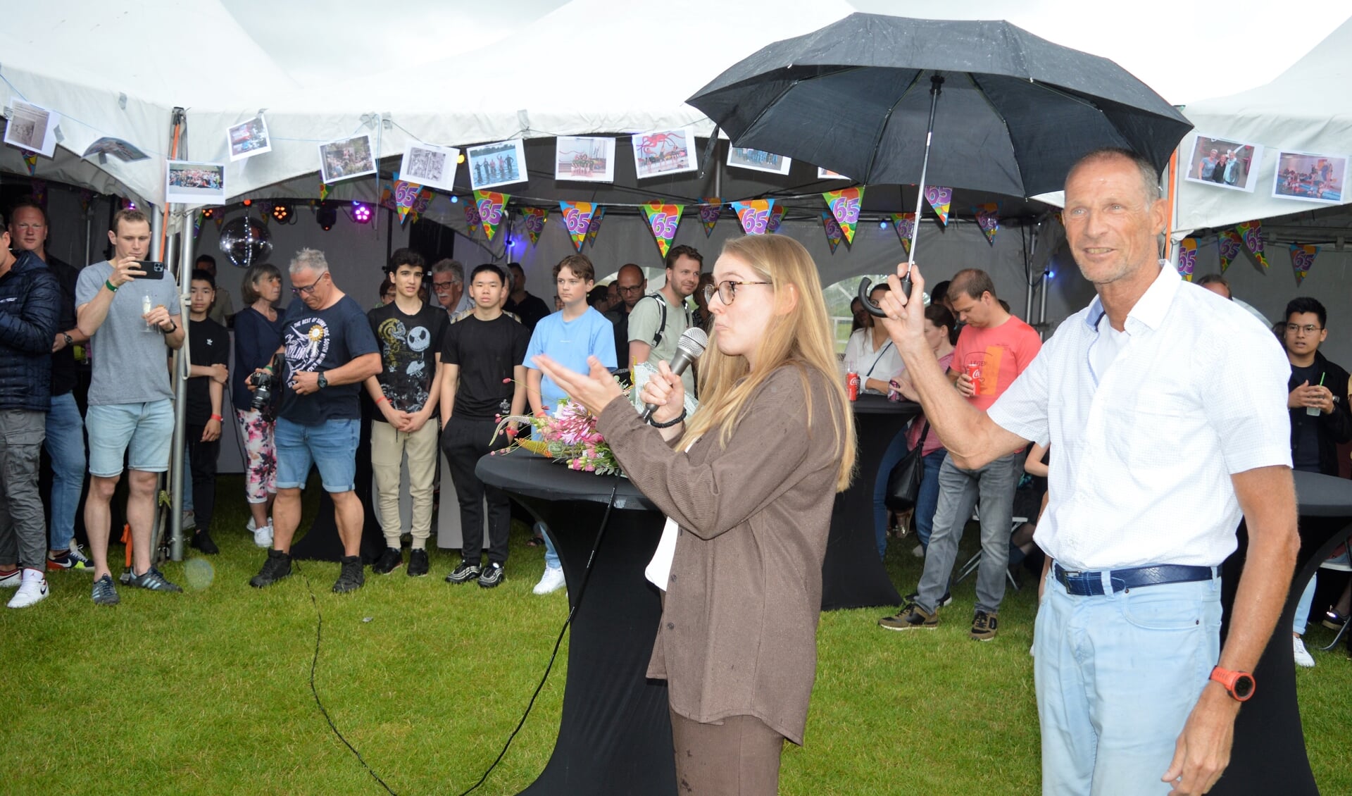 Voorzitter André den Exter houdt de paraplu op voor wethouder Fleur Stip