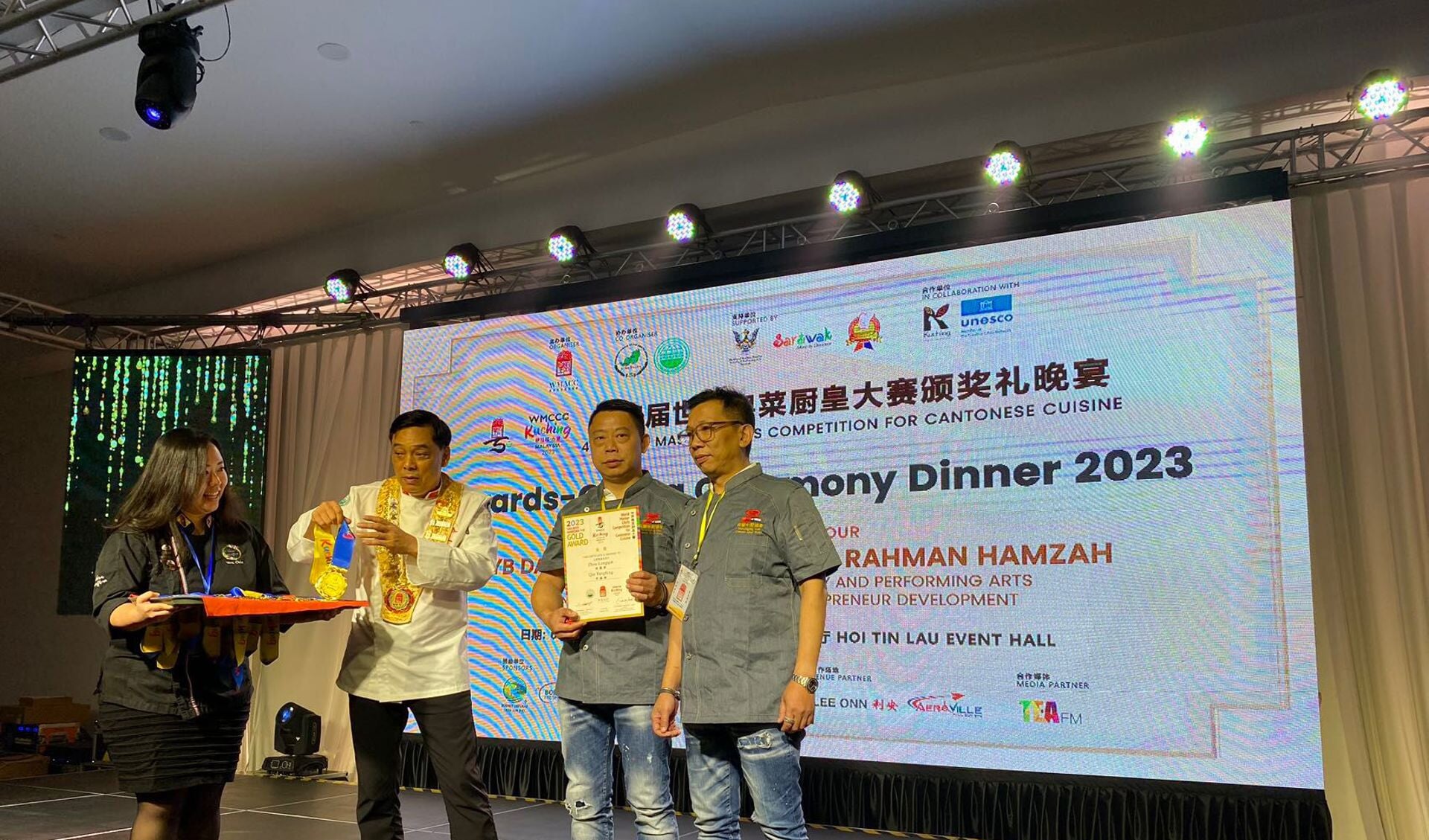 Long-Qin Zhou (met oorkonde) en Yangfeng Qin op het podium voor hun gouden medailles