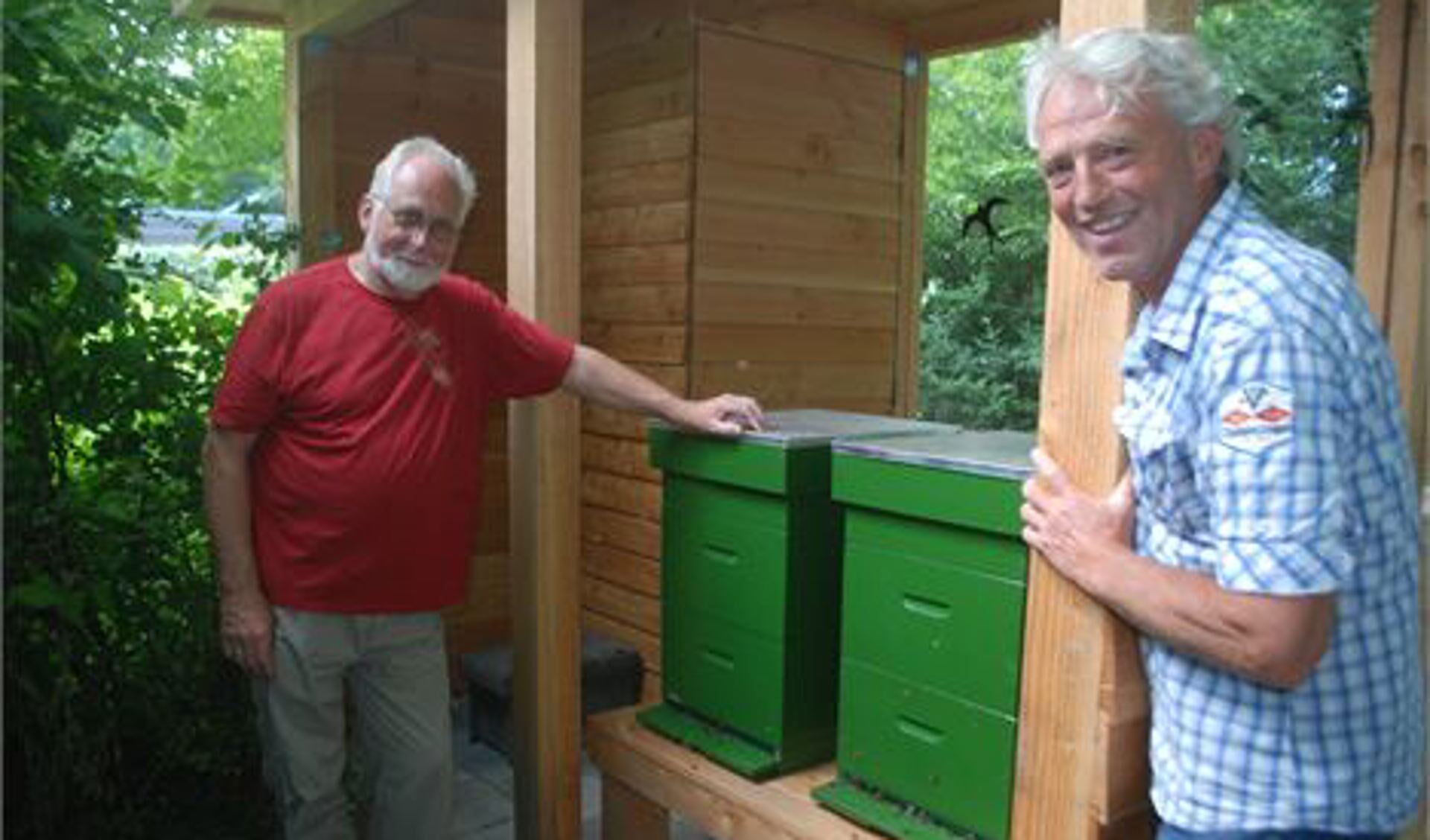 De Ridderkerkse bijenhouders Jan Tuin (links) en Wim Kock zorgen als imkers voor de twee bijenkasten die bij de vlindertuin van het NME-centrum zijn geplaatst.