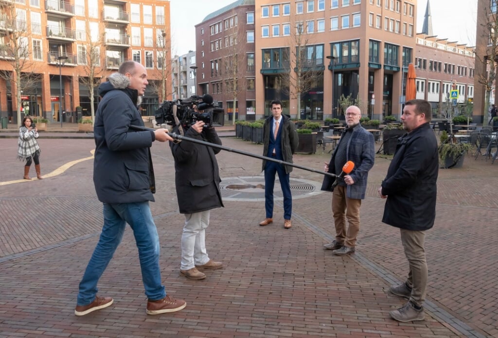 De wethouders Henk van Os, Marco Goedknegt en Arnoud Proos voor de camera op het Koningsplein