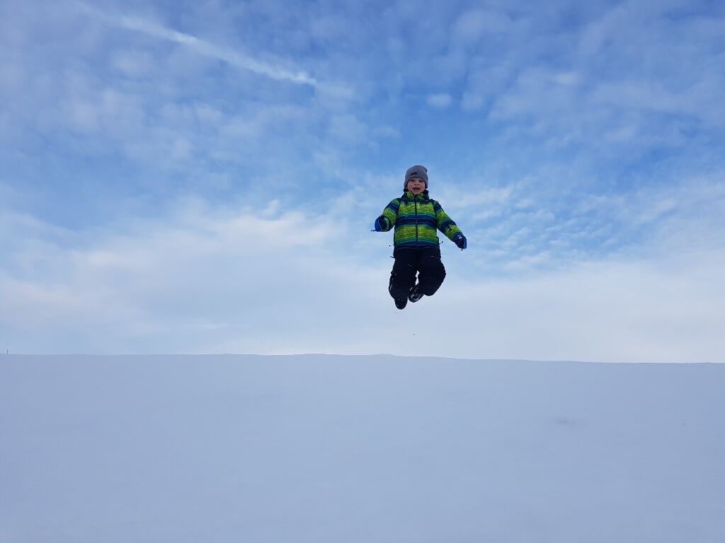 Tim Polfliet (10) springt van een besneeuwde dijk 
