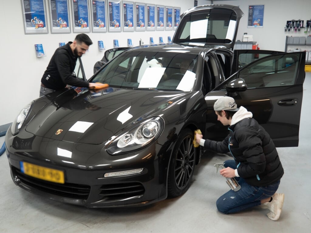 Met drie medewerkers tegelijk wordt de auto snel, maar grondig, schoongemaakt en gepoetst.