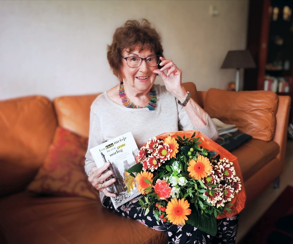 Jopie Roije met boek en bloemen. 