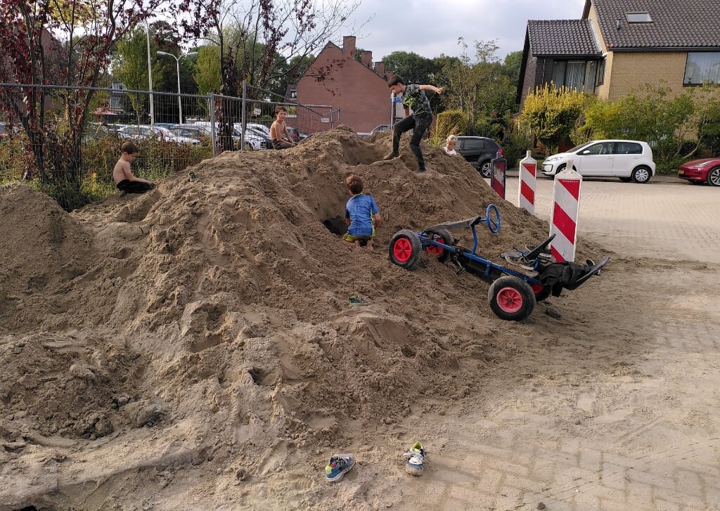 In Buitenoord is aan de straat gewerkt. Kinderen hebben dankbaar gebruik gemaakt van de zandberg in de Kempenaar.