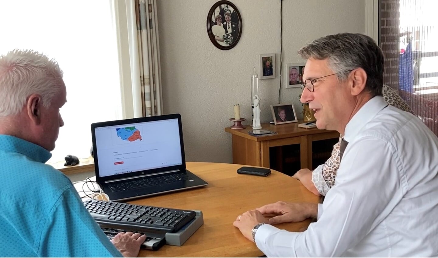 Burgemeester Wim Hillenaar op bezoek bij Gravenaar Wim Pierik, die uitlegt hoe hij de gemeentelijke website bekijkt.