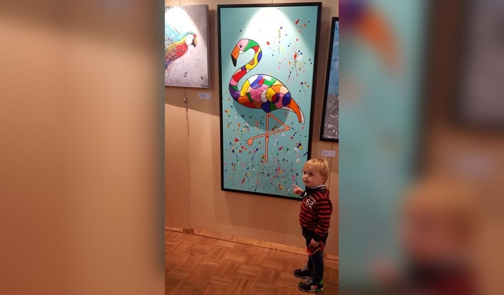 Een jonge bezoeker laat zien welk kunstwerk hij het mooiste vindt.