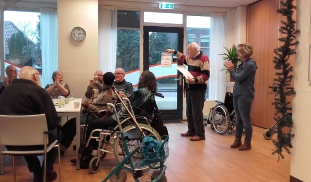Frits Bentsink laat de cheque van 360 euro zien aan de deelnemers bij Interakt Contour. Foto: Annemieke van Ipenburg.