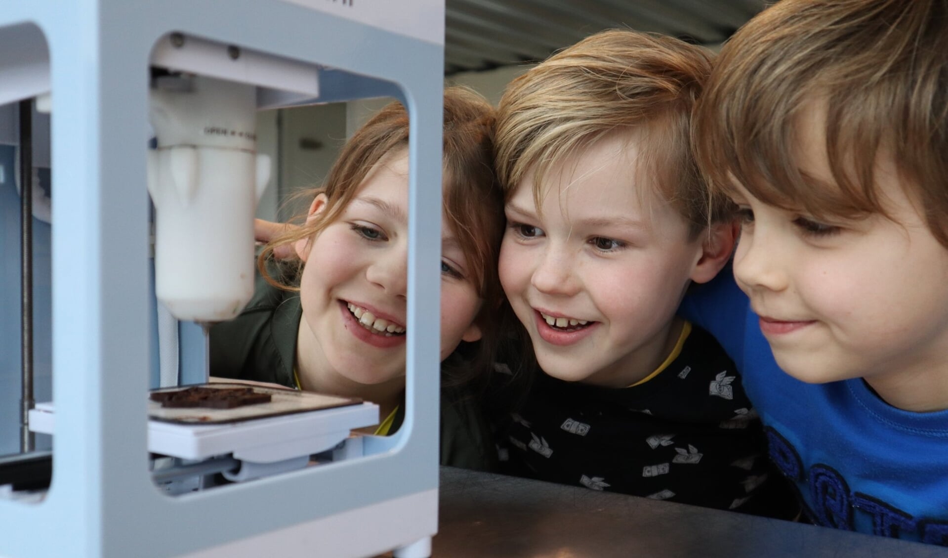 Een 3D printer maakt met chocolade als inkt een letter.