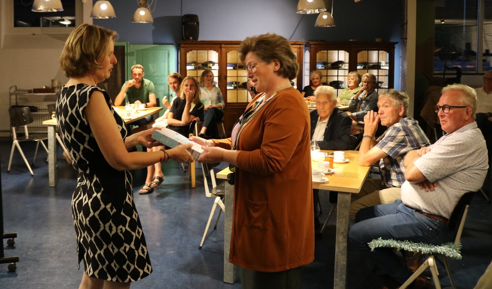 Marja Voortman (links) overhandigt een exemplaar aan secretaris Jennet van der Harst van het museumbestuur.