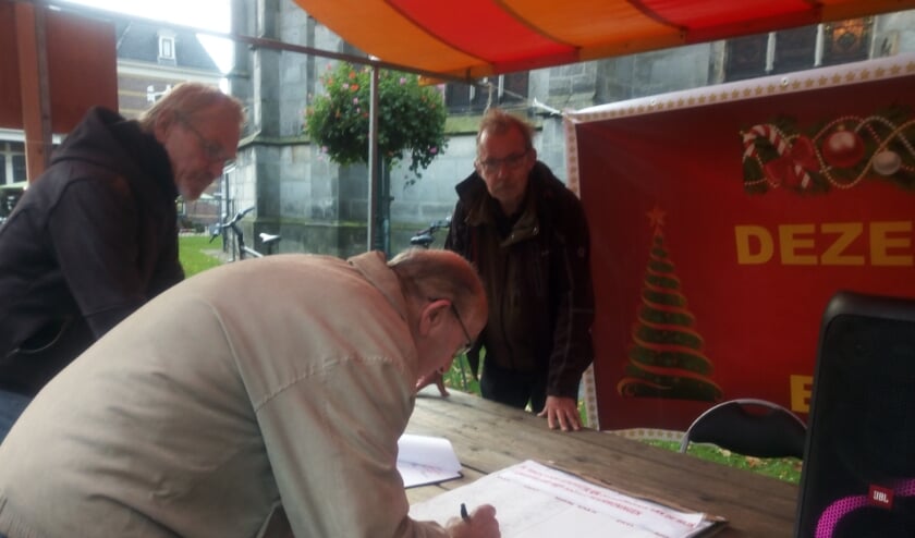 <p>Een bezoeker van de weekmarkt zet zijn handtekening voor behoud van de woningen aan het Zwarteland. Meer handtekeningenacties volgen. </p>