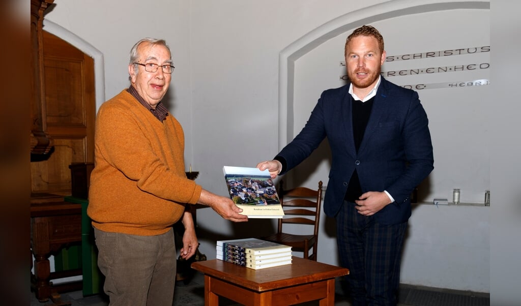Roy de Witte (rechts) neemt uit handen van Frits Korver het eerste exemplaar van 'Rondom 'n Oalen Griezen' in ontvangst. Een boek dat mede dankzij een provinciale subsidie voor een mooie prijs tot stand is gekomen.