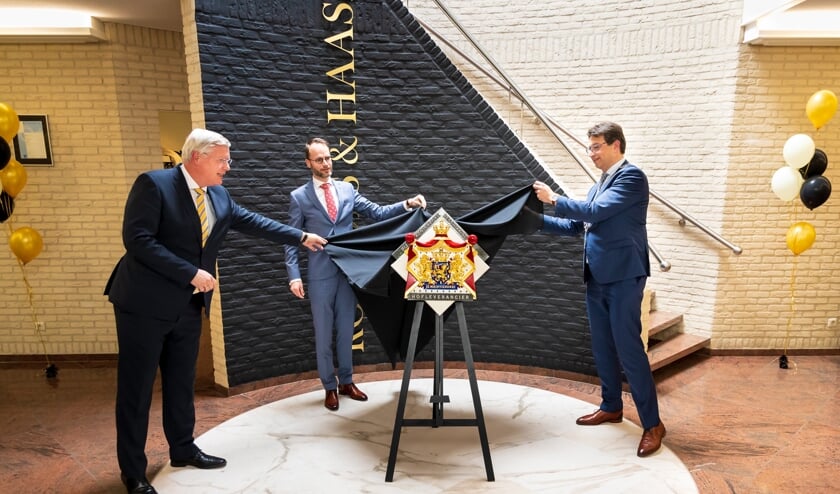 <p>RIJSSEN - Commissaris van de Koning Andries Heidema (links), RoHa-directeur Nico Haase (midden) en locoburgemeester Bert Tijhof onthullen het Hofleverancier-wapenschild.</p>