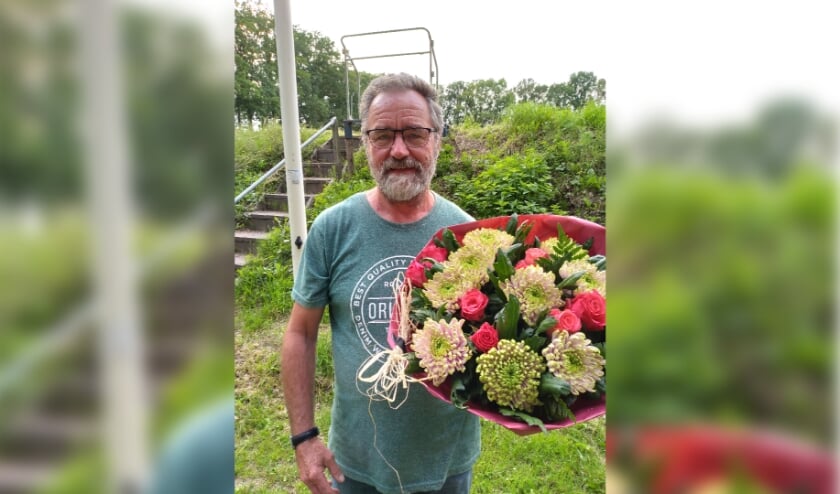 <p>Mannes Pijffers ontvangt een grote bos bloemen, omdat zijn jonge duif als eerste terugkeert op het hok vanuit Beek en Donk</p>