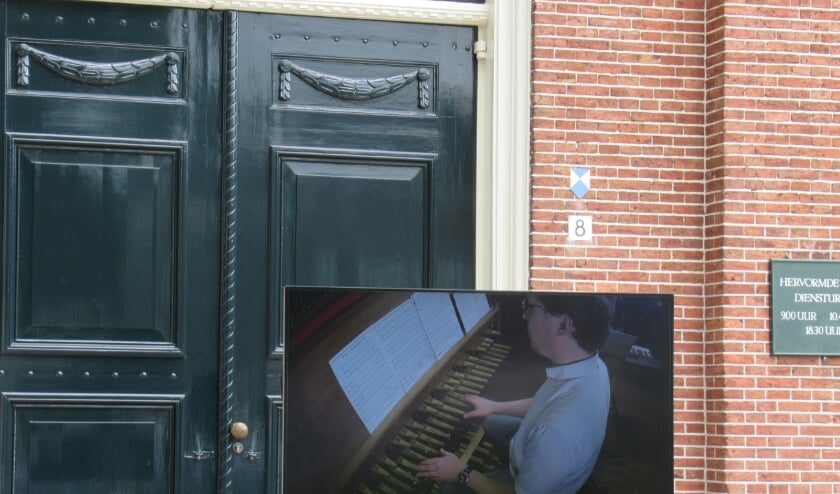 <p>Beiaard en organist Jan-Geert Heuvelman was goed in beeld op het grote scherm bij de ingang van de kerk</p>