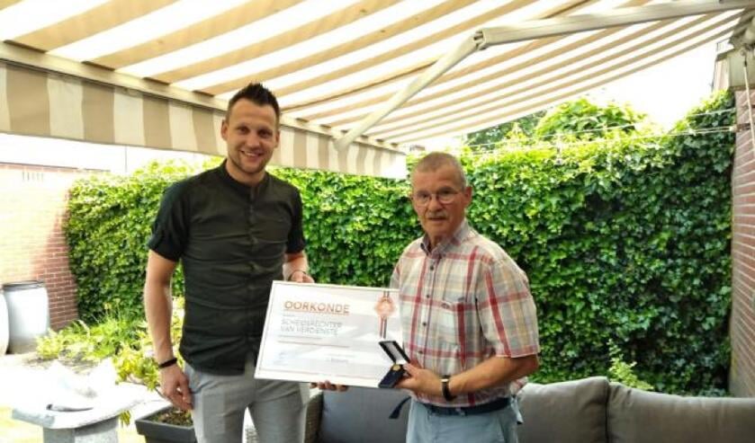 Johan Schwarte ontvangt de oorkonde en bijbehorende spelt uit handen van KNVB medewerker Lennart Fledderus