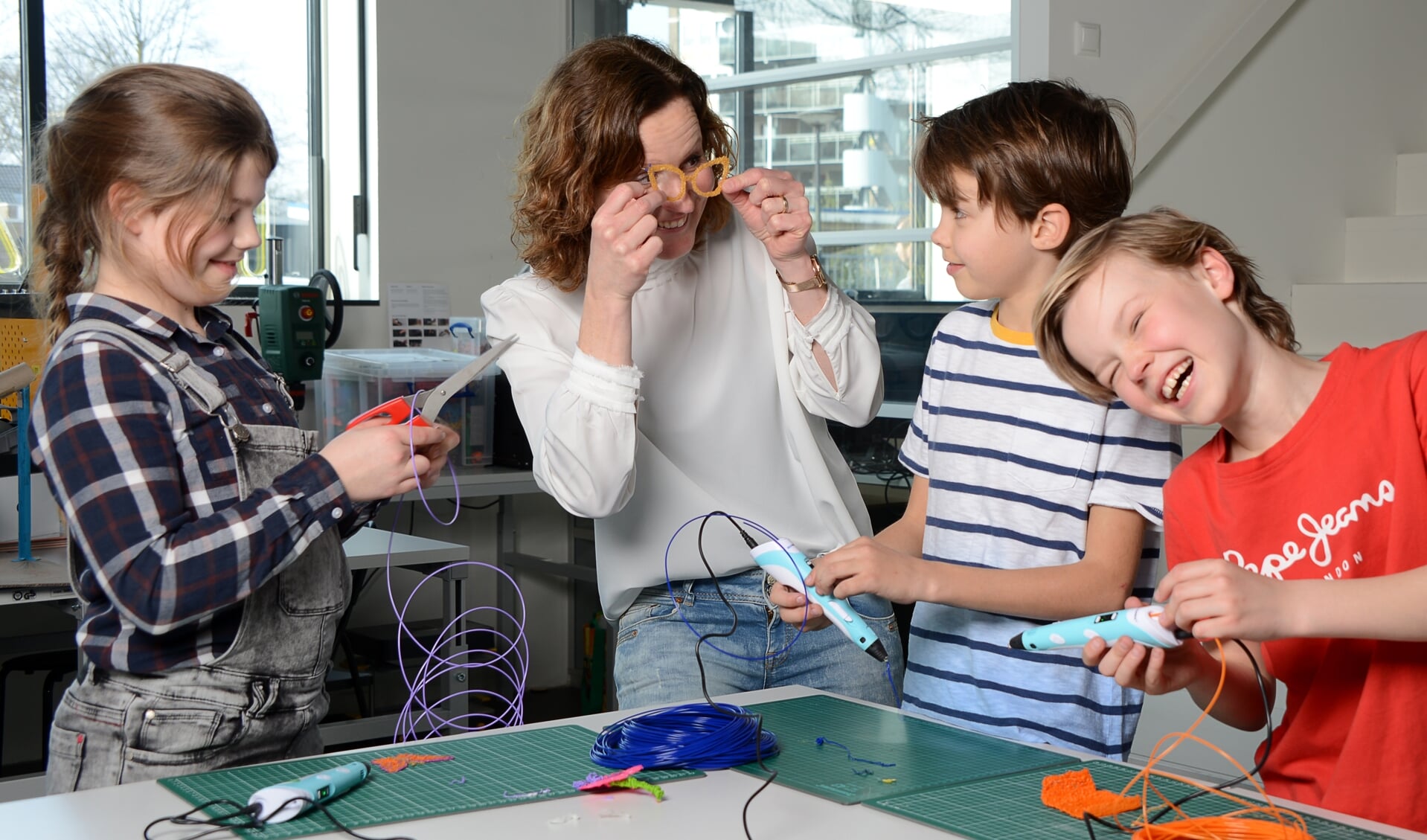 Pleun Burks, Wencke Steggink (Tetem), Nilson Boensma en Gijs Steggin, bezig met het maken van een bril m.b.v. een 3D-pen. Foto: Linda Meijer