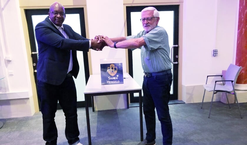 <p>Buddy Peter Blankeslijn reikt asielzoeker Herme letterlijk en figuurlijk de hand, net als hun nieuwe logo! (Foto: PR)</p>