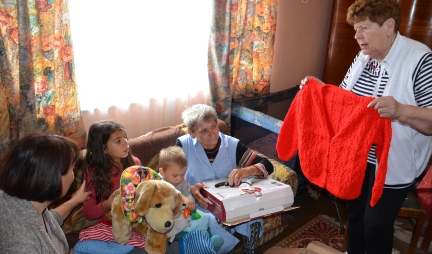 <p>Riky Schonenborg deelt kleding uit aan arme Roemenen. Foto: Raymond Wegdam. </p>