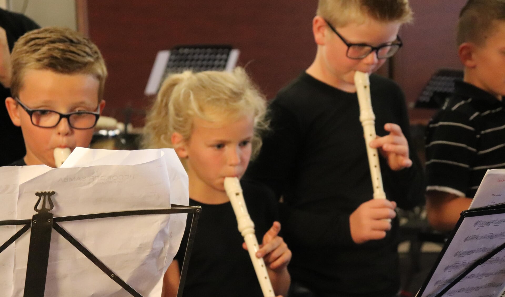 Kinderen leren door onder meer het bespelen van de blokfluit muziek te maken tijdens de AMV-lessen.