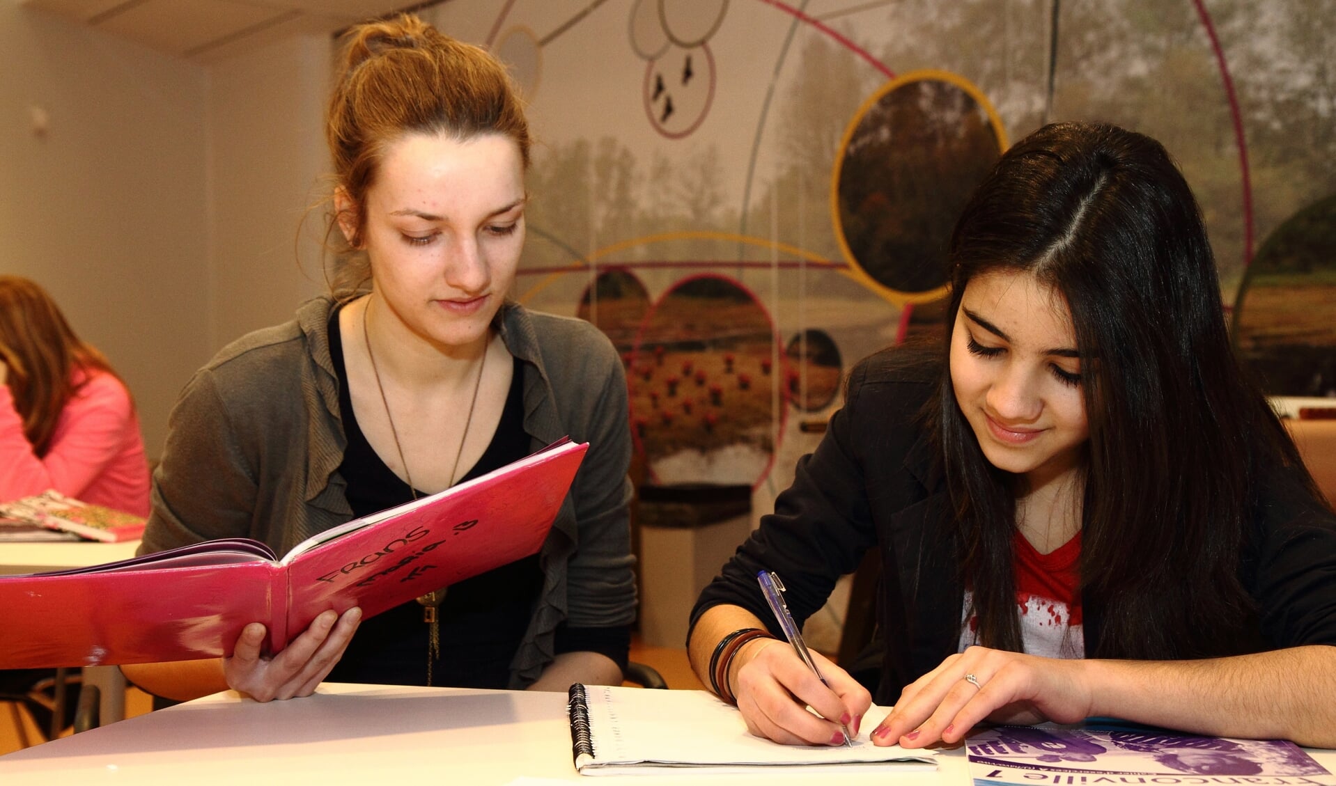 Een scholier krijgt uitleg bij het huiswerk. 