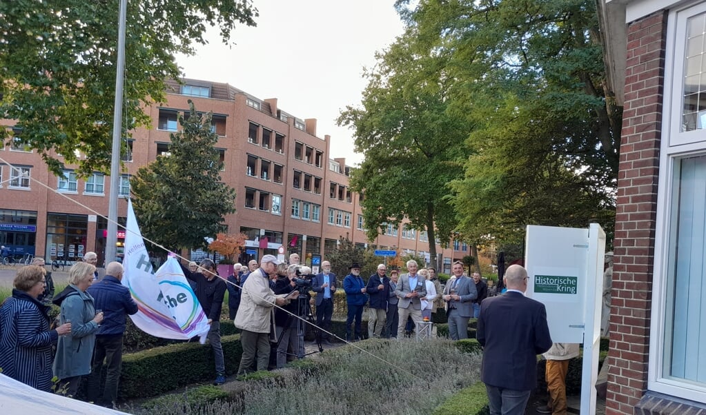 Na een druk op de knop van voorzitter Eddy Muis en burgemeester Jorrit Eijbersen openden zich de vensters (rechts) en werd de vlag met het nieuwe logo gehesen.
