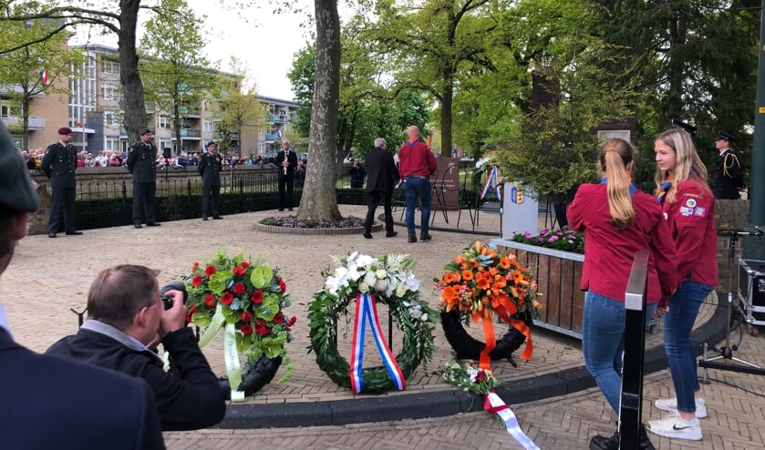 Oud-Indiëganger Gerrit Harbers (94) legt een krans bij het oorlogsmonument. Op de achtergrond de erewacht en hoornblazer Johan Kalter.