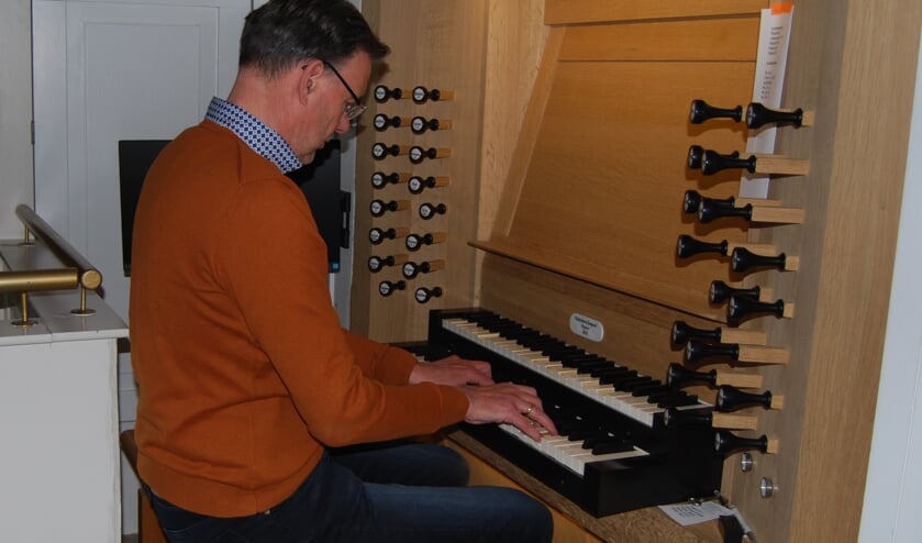 Organist Otto Zwolsman achter de speeltafel van het orgel in de Tabernakel.   