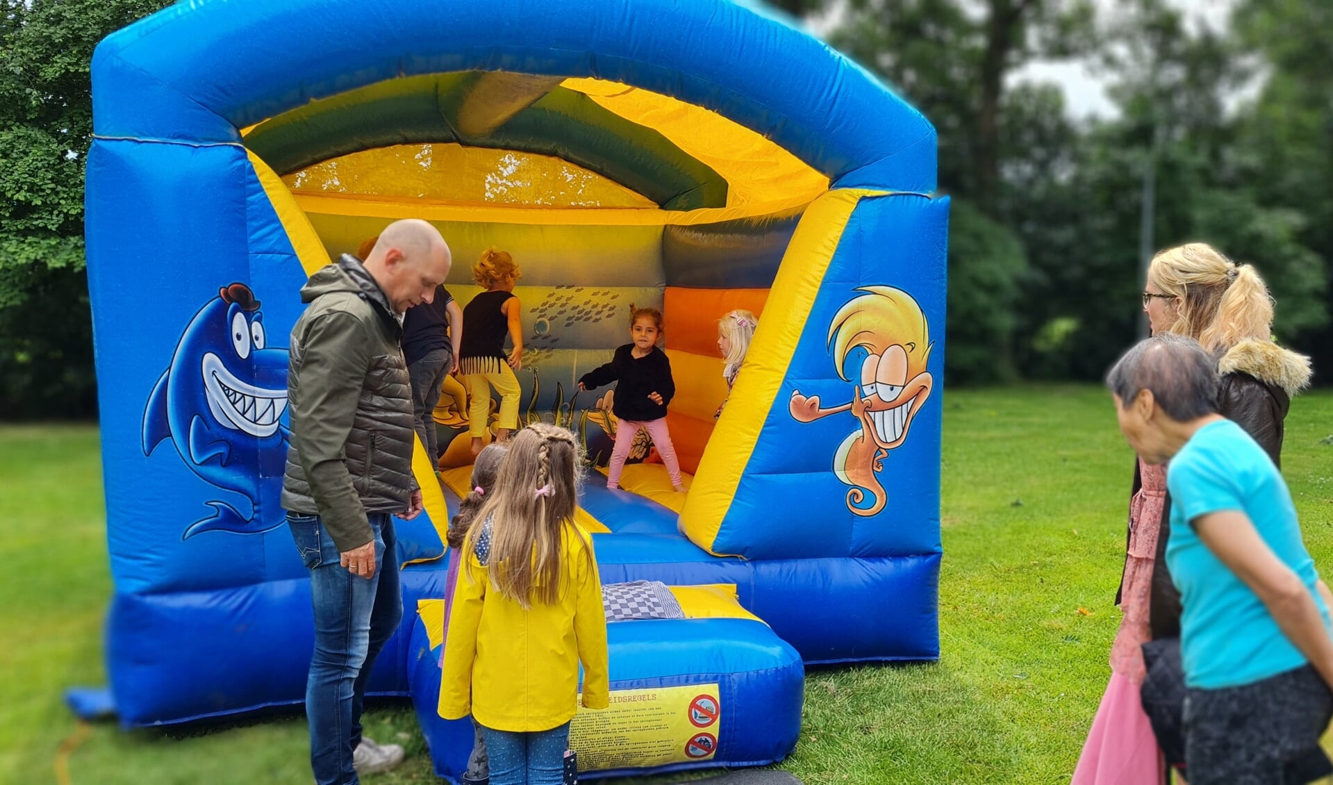 Kinderen doken op het springkussen tijdens de nationale buitenspeeldag bij de Mensingboerderij. (foto: Henrike Schuitemaker)