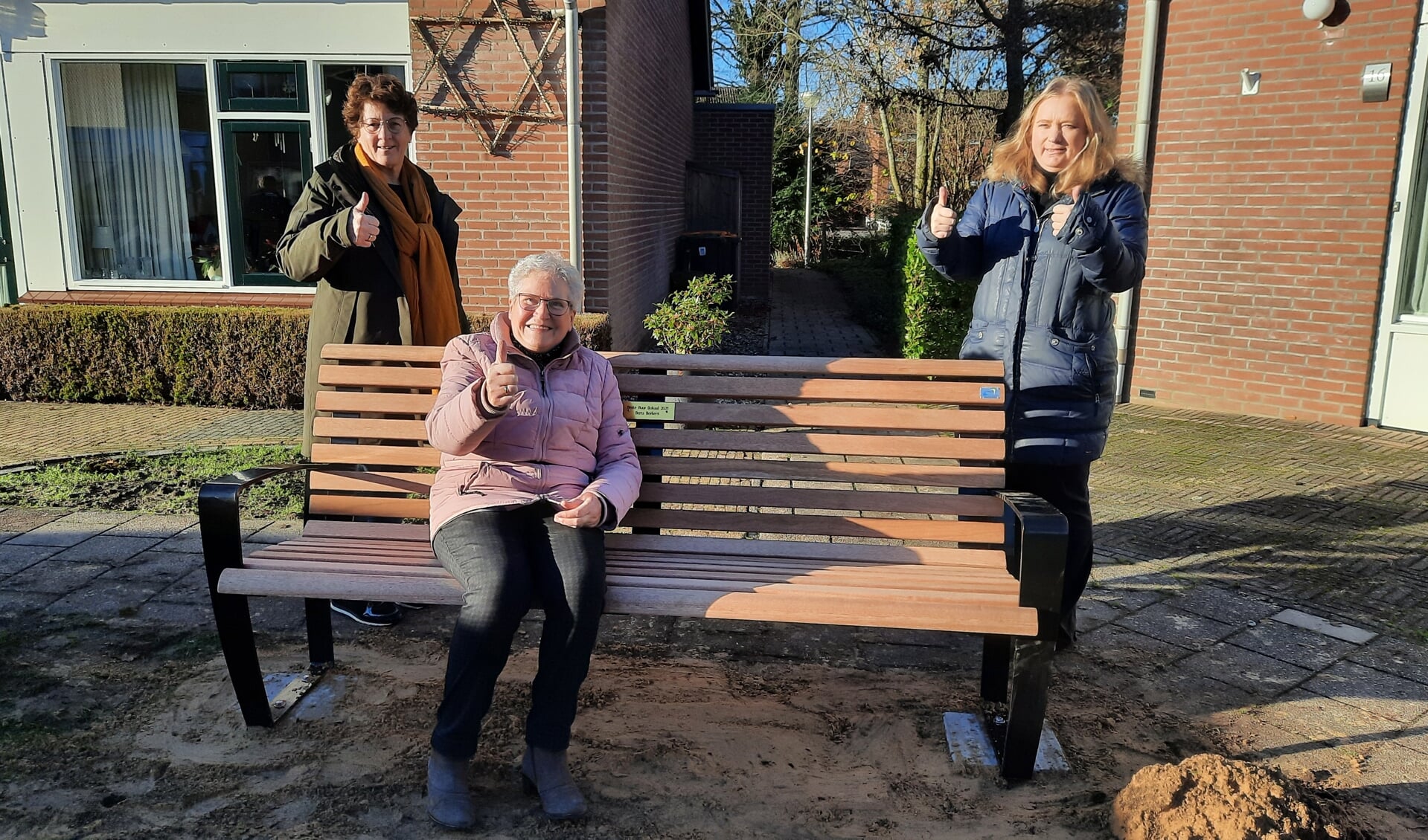 De winnaar van 2021 in Wierden mevrouw Borkent, helemaal tevreden op  haar gewonnen buurtbankje waar de hele buurt zich vast vaak gaat verzamelen.