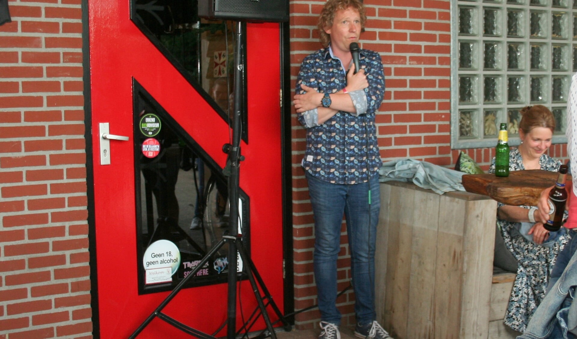 Thijs Kemperink vermaakt het publiek. Onder: Comedy op een bijzondere plek: in een garage.