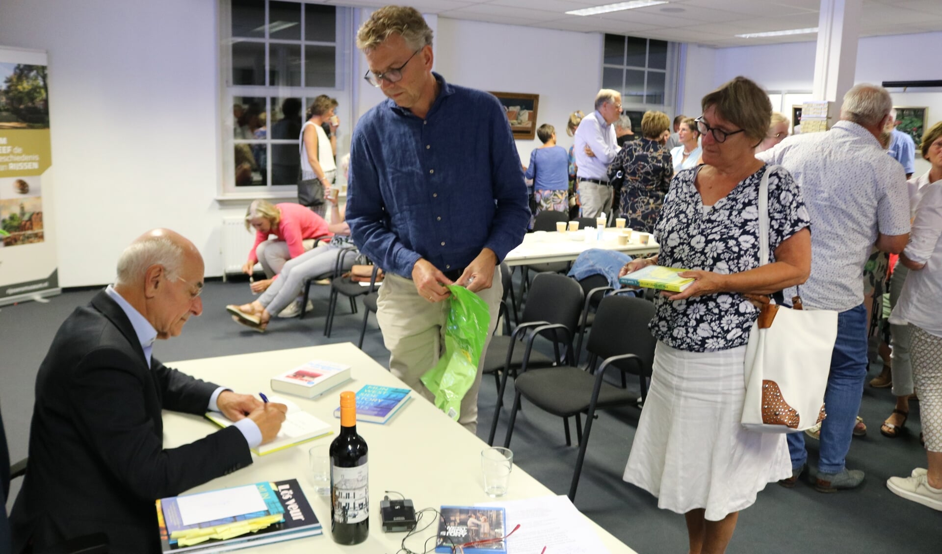 Frits Spits signeert in het Koetshuis aan de Kasteellaan, nadat hij had verteld over zijn boeken en werk.