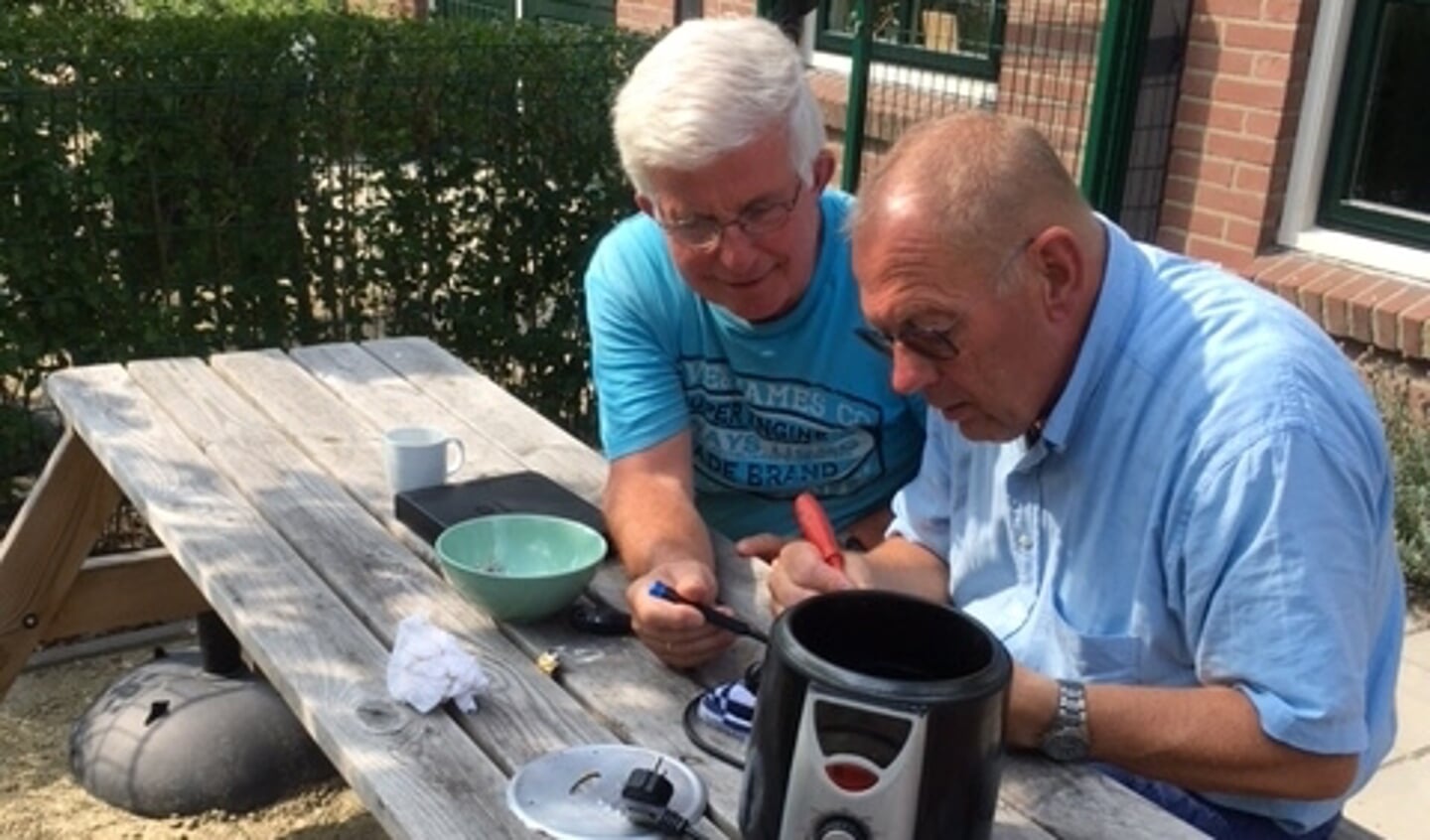Vrijwilligers van het Repair Café aan het werk.