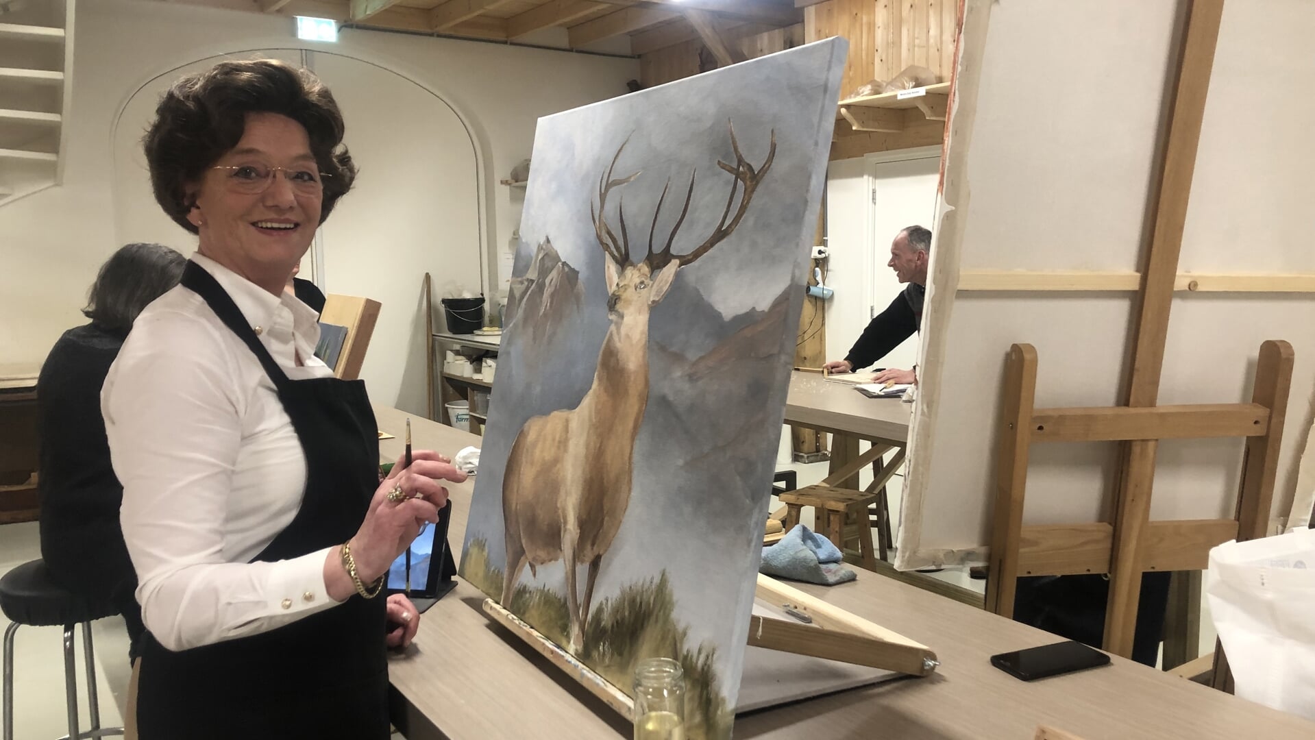 Erna Brinks schildert in de Hobbyboerderieje een edelhert op linnen doek.