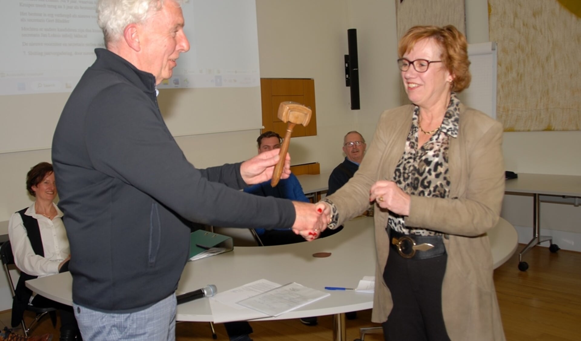 Aftredend voorzitter Eddy Muis overhandigd Anneke Raven de voorzittershamer van de Historische Kring Hellendoorn-Nijverdal. (Foto: Hepa)