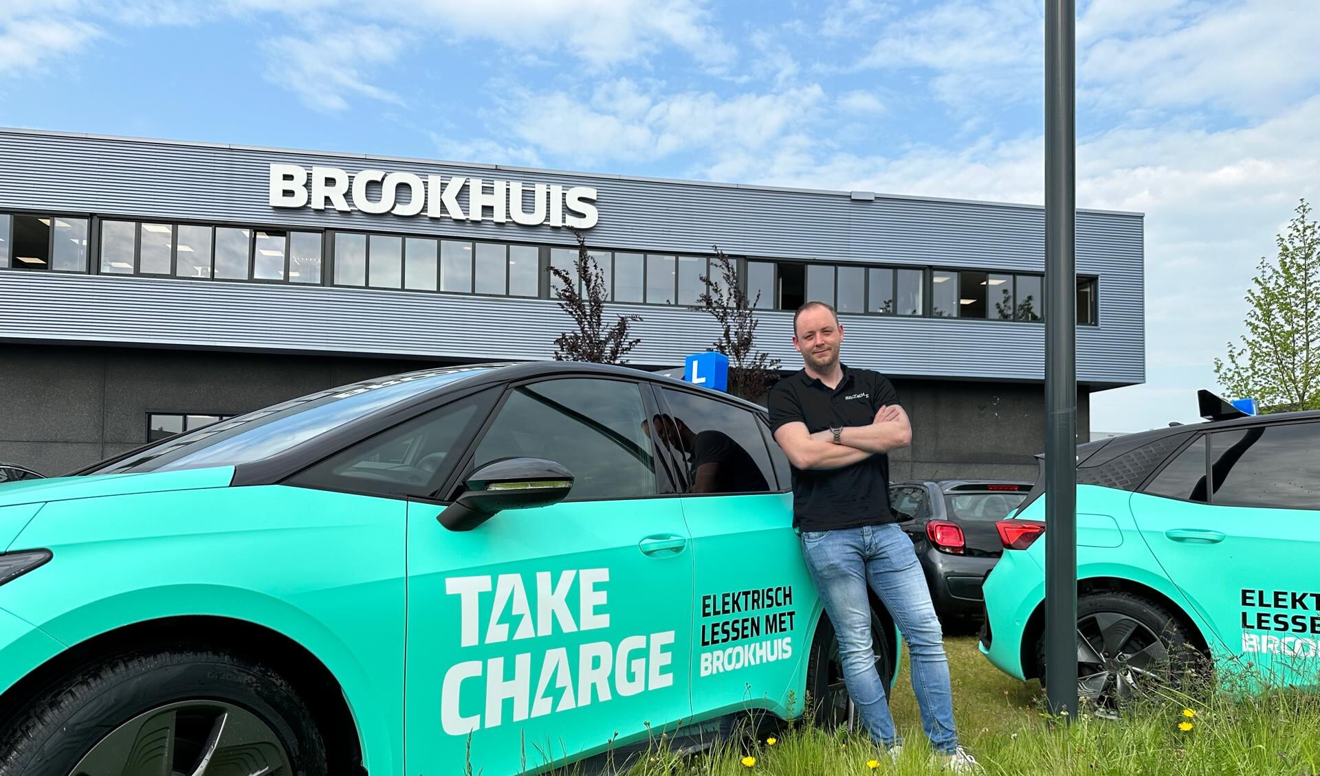 Peter Hofstee (rijinstructeur bij Brookhuis) bij de gloednieuwe elektrische leswagens van Take Charge, waarin vanaf 1 juni rijlessen worden gegeven.