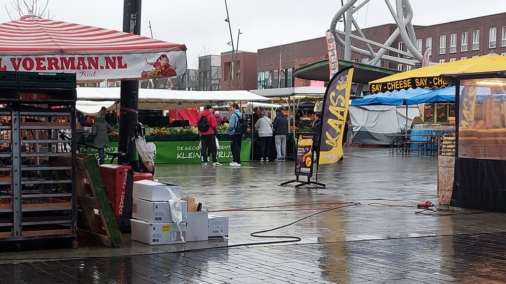 De dinsdagmarkt in Enschede trekt ondanks de regen bezoekers.