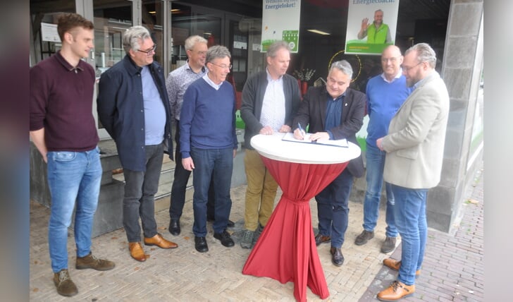 Wethouder Michel Geerdink tekent de samenwerkingsovereenkomst namens de gemeente onder het toeziend oog van het bestuur van DiBo.