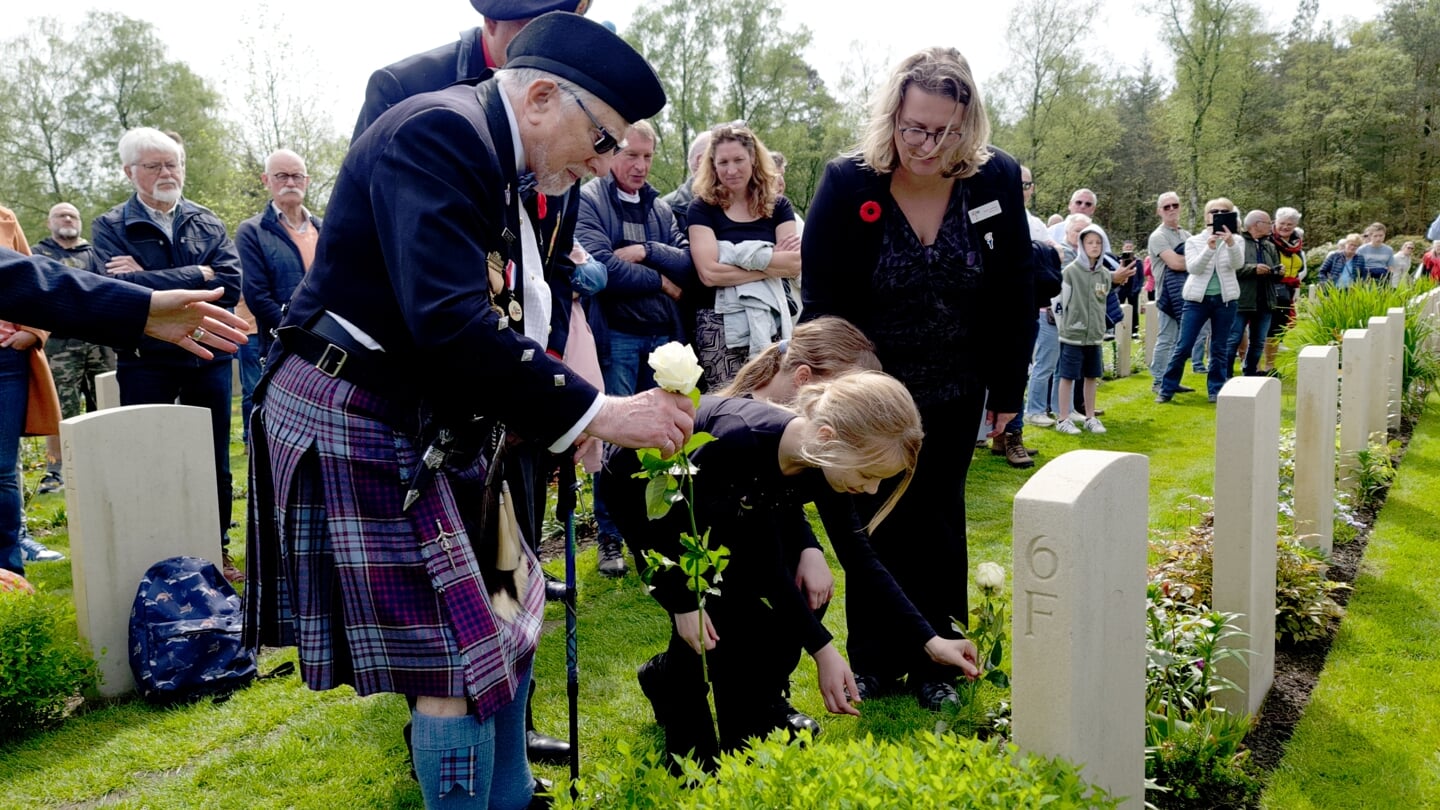 De 101-jarige Canadese veteraan George Brewster plaatste met de hulp van twee kinderen rozen bij de steen van de gesneuvelde soldaat John Hergott..