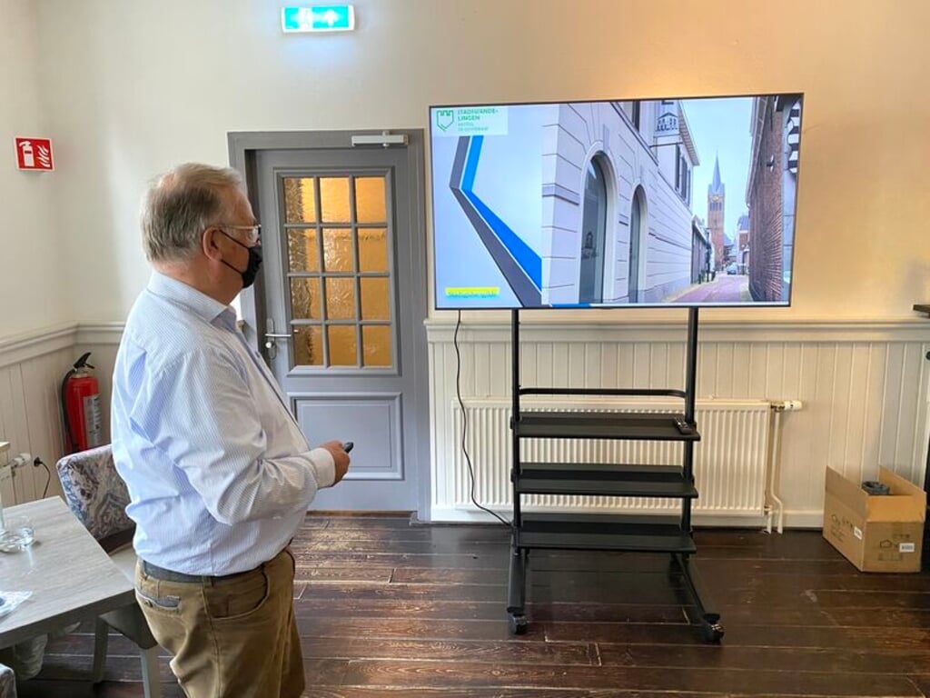 RIJSSEN - Stadsgids Cees Proos demonstreert het nieuwe scherm bij Brasserie-Uit.