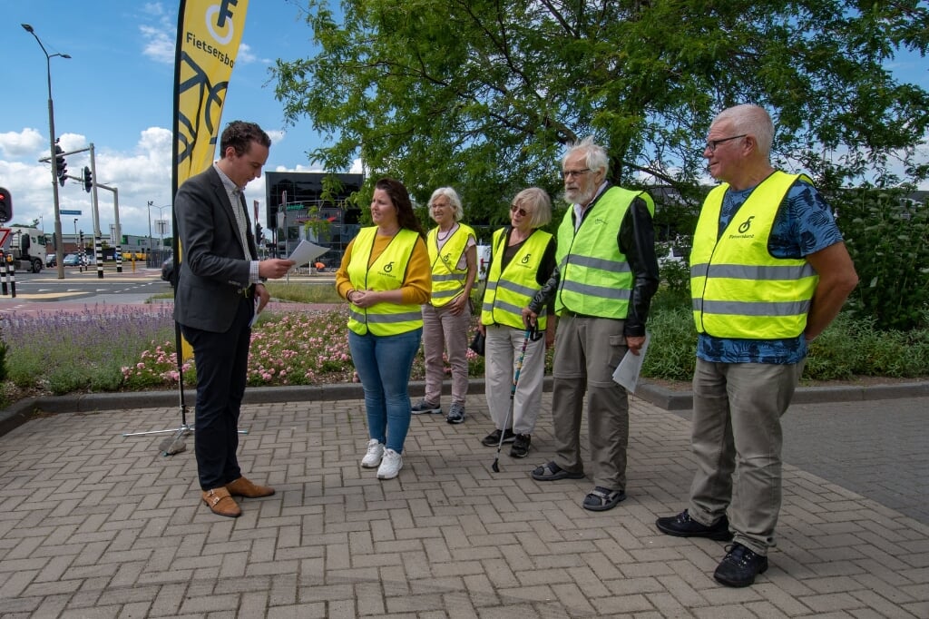 Wethouder Arjen Maathuis krijgt van de Fietsersbond de uitslag van een enquête over het verkeersplein Plesmanweg.  