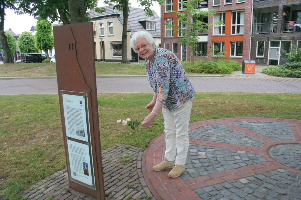 Marietje Hofmeijer buurtbewoonster legt rozen bij de sociale sofa.