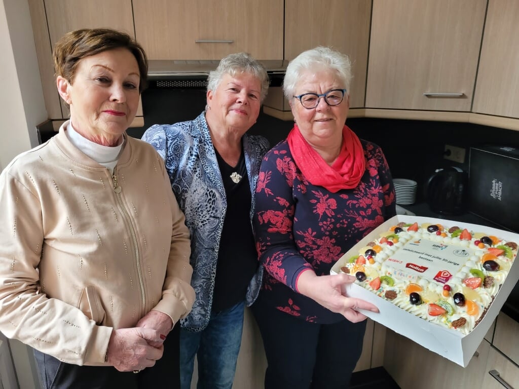 Wil Kerkhof, Kiet Scholten en Ine Elslo nemen taart in ontvangst.