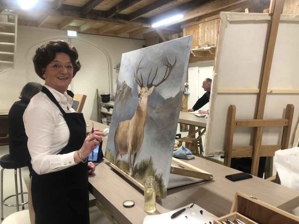 Erna Brinks schildert in de Hobbyboerderieje een edelhert op linnen doek. 