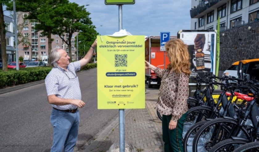 Een van de nieuwe eHUB is in Hatert. Wethouder Tiemens (rechts) van gemeente Nijmegen onthulde het bord, samen met een buurtbewoner.  